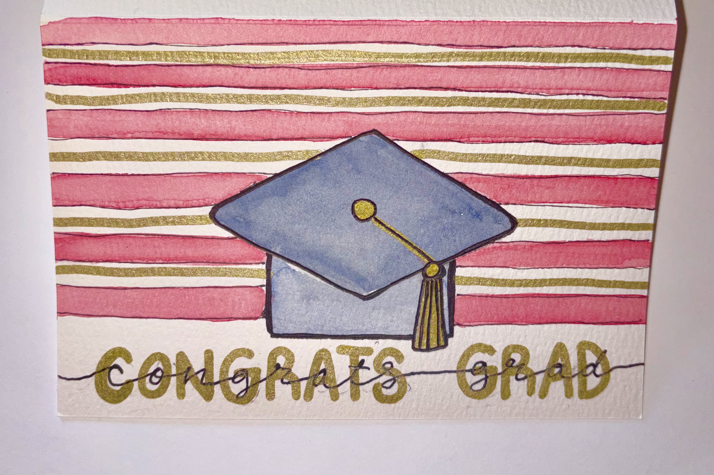 Watercolor graduation card with pink stripes and gold lettering